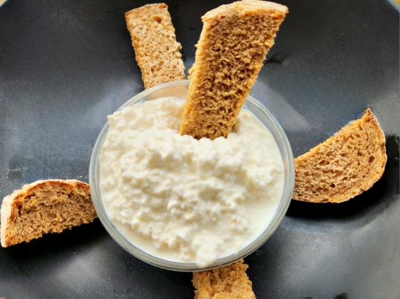 cottage cheese in glass bowl with toast pieces dipped in