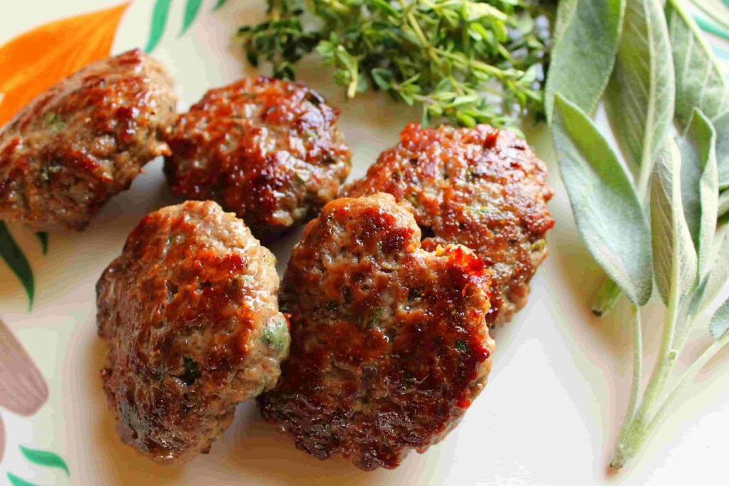 elk breakfast sausage patties on plate with fresh herbs
