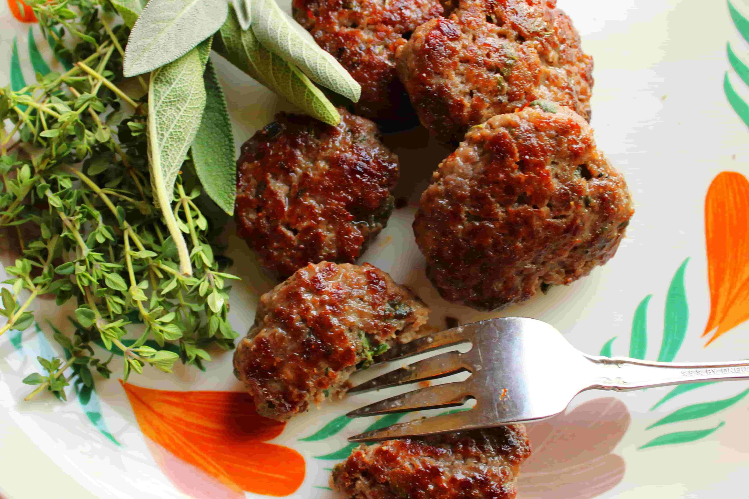elk breakfast sausage patties on plate with herbs and fork