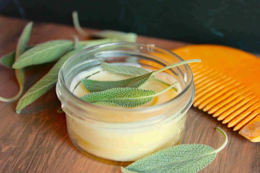 beard butter in glass container with wooden comb and herbs