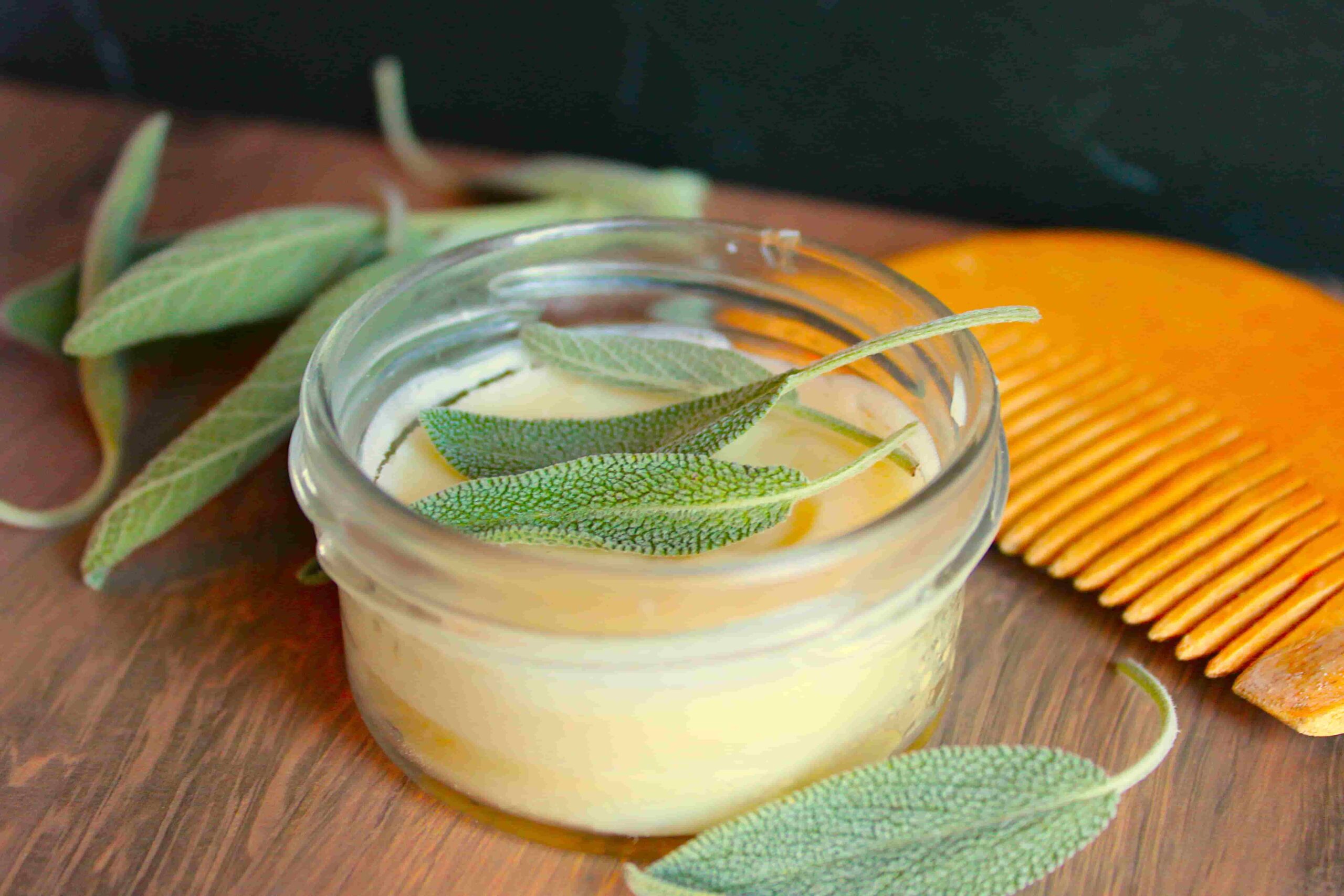 beard butter in glass container with wooden comb and herbs