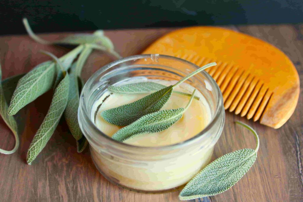 beard butter in glass container with wooden comb and herbs