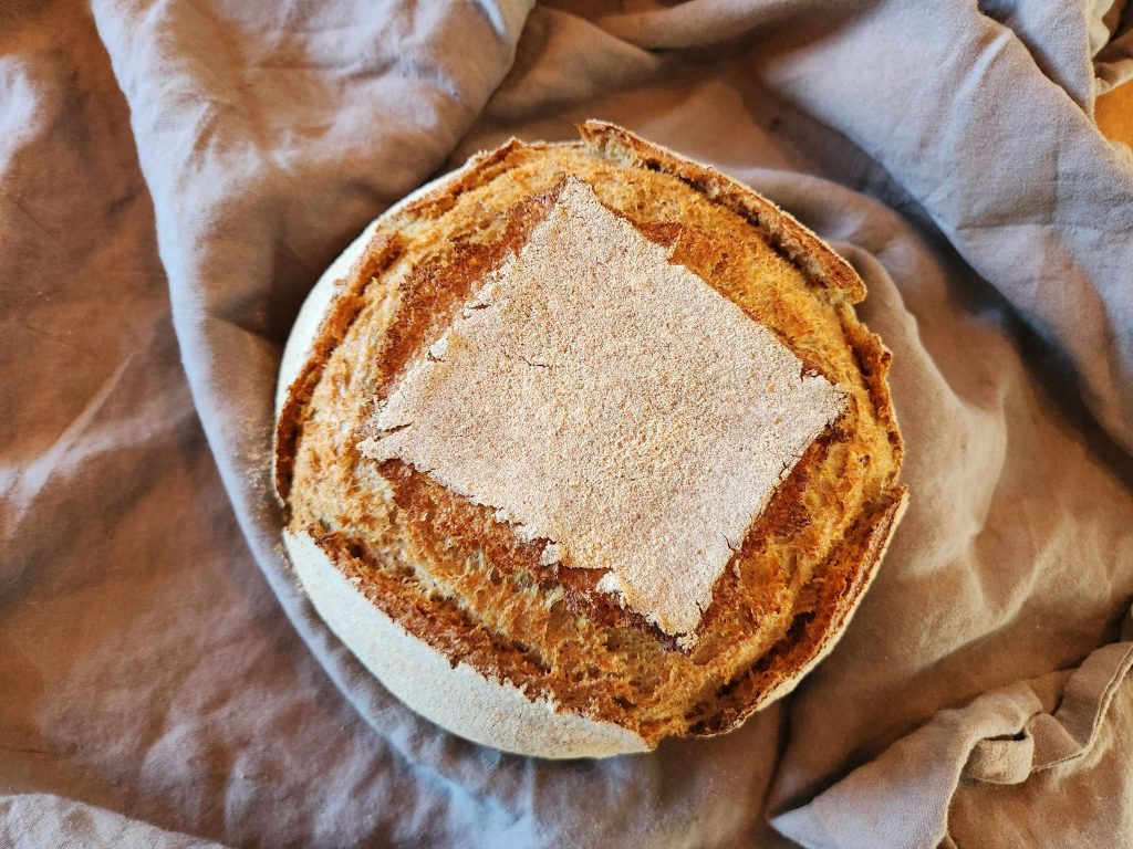 baked ancient grain sourdough boule on linen cloth