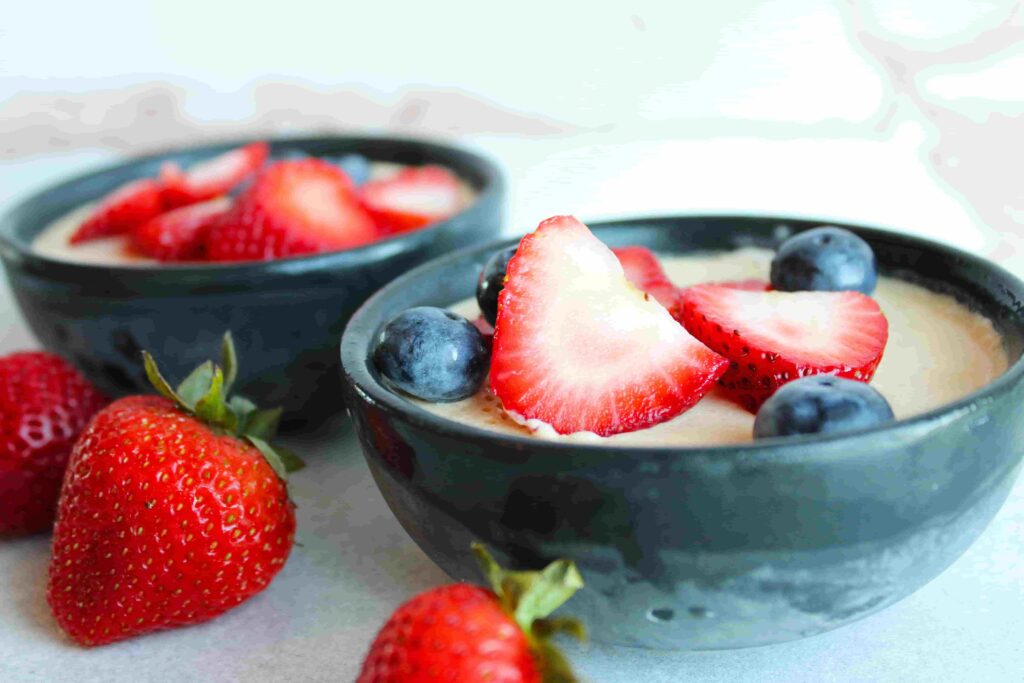 no bake cheesecake in small black bowls with fresh berries on top