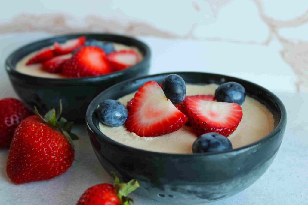 no bake cheesecake in small black bowls with fresh berries on top