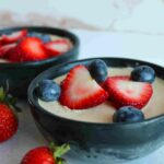 no bake cheesecake in small black bowls with fresh berries on top