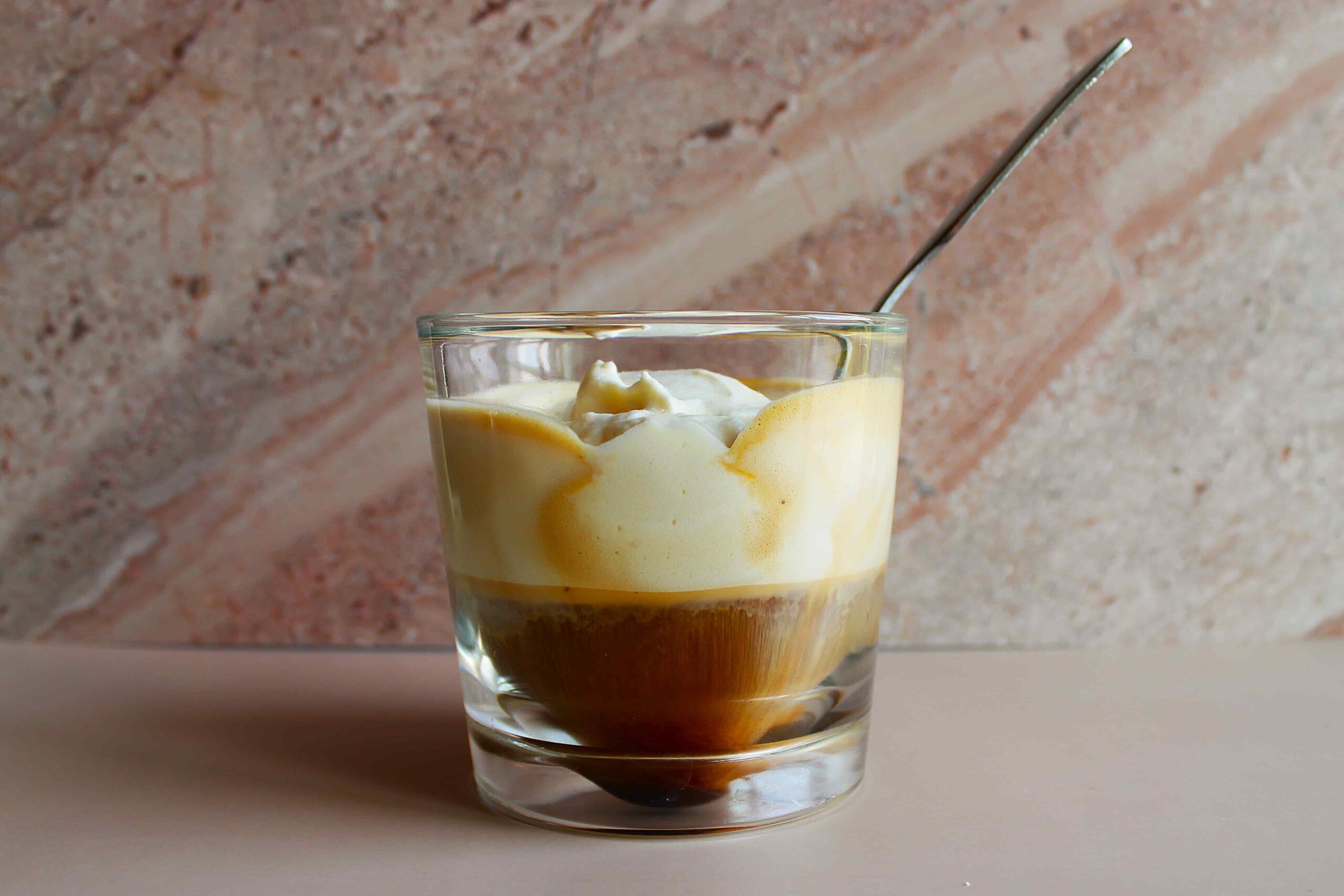 espresso con panna in glass cup with spoon