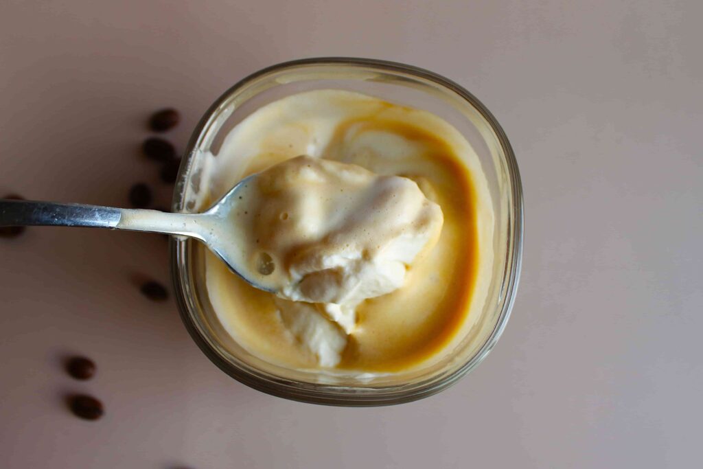 enjoying espresso con panna with a spoon