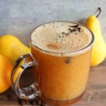 homemade spiced pear cider in glass mug with pears