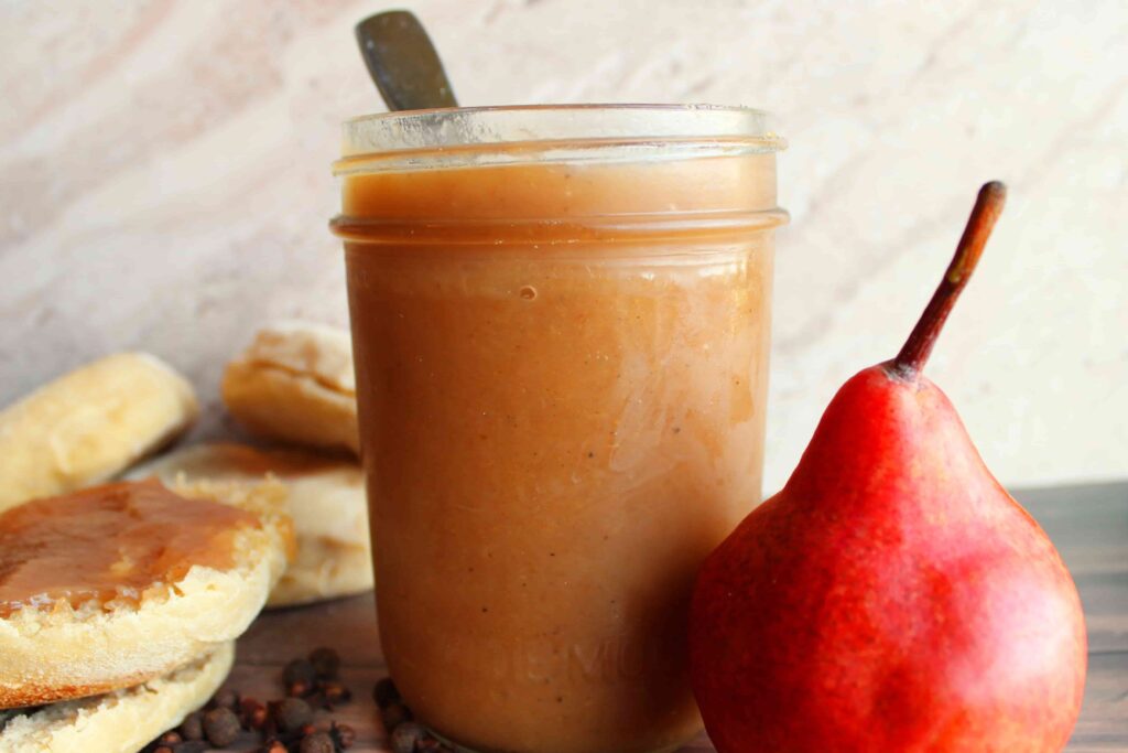 easy homemade pear butter in a jar with a fresh pear