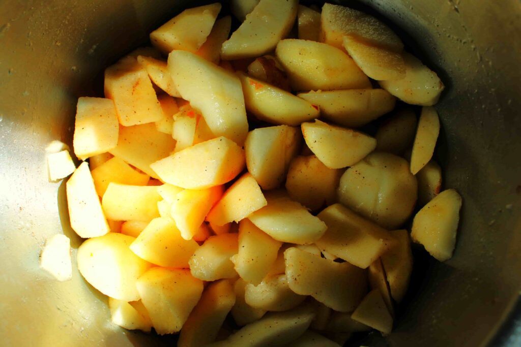 chopped pears in instant pot with spices, water, lemon juice, and maple syrup