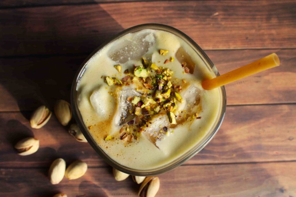 pistachio latte in glass with ice and crushed pistachios