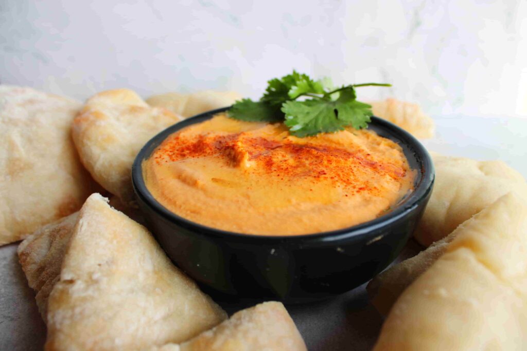 roasted red pepper hummus with no tahini in bowl with pita bread on the side
