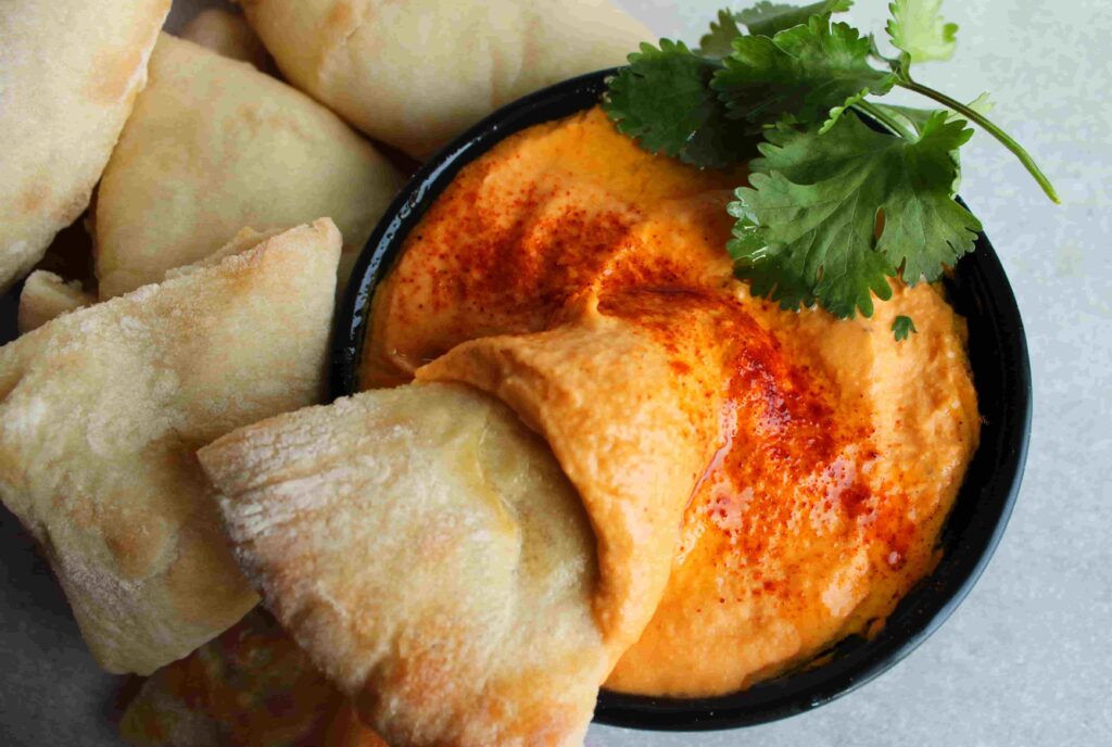 roasted red pepper hummus no tahini in bowl with pita dipped in
